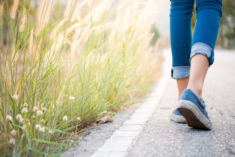 Close-up of woman's feet as she walks along the path.