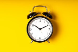 Analog alarm clock symbolizing the week-by-week duration of the liposuction recovery timeline and the patience needed for final results.